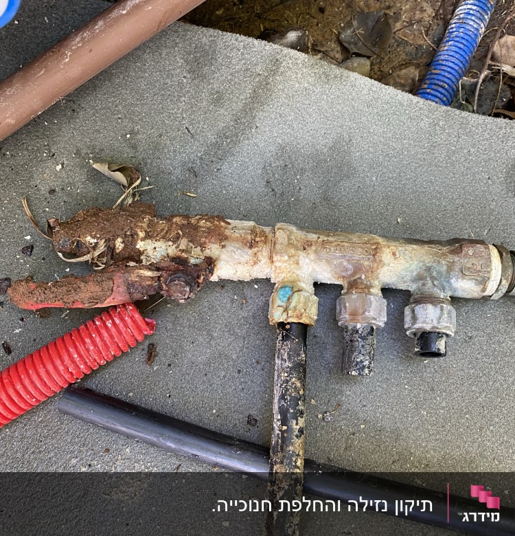 צינור חלוד עם חיבורים ומחברים על הקרקע